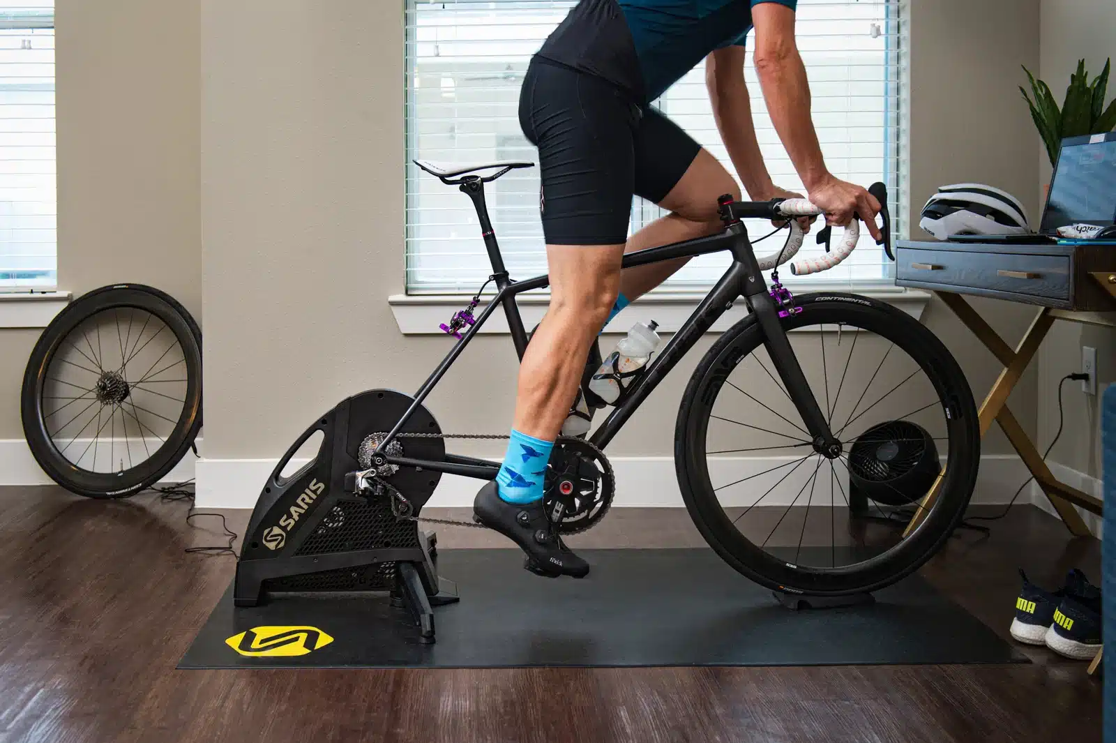 רוכב מתאמן על Saris H3 המוצב על שטיח Saris Trainer Mat